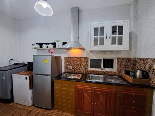 a kitchen with a refrigerator and a sink at Bluepool Villa Pattaya in Bang Sare