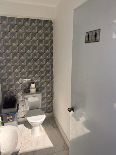a bathroom with a toilet and a sink at Crown ll-3 Bedrooms-Pool-Close to everything! in San Felipe de Puerto Plata