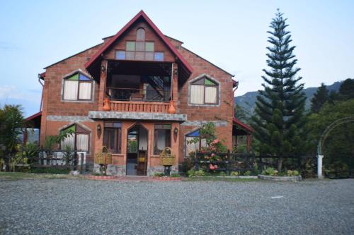a brick house with a porch and a balcony at Finca Hotel Villa Mia in Girardota