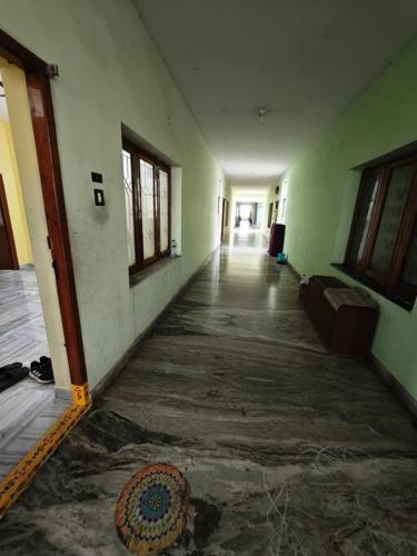 an empty hallway of an old building with a rug at House-of-G 3bhk newly painted flat in AVA road Rajahmundry in Godāvari