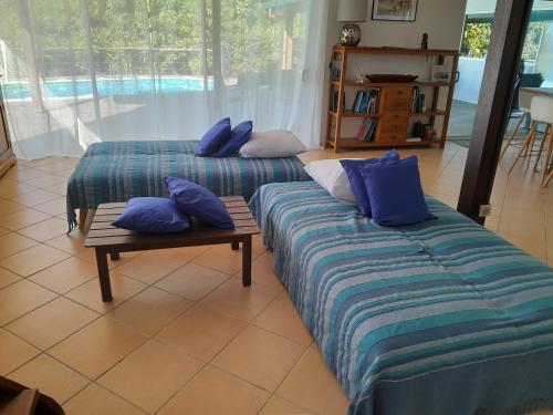 - 2 lits dans une chambre avec des oreillers bleus dans l'établissement Villa Blue Horizon Moorea, à Teavaro