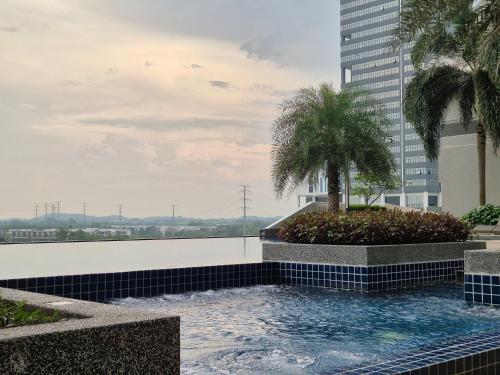 a swimming pool with a palm tree on top of a building at Medini Family suites for 3 pax - Next to Legoland in Nusajaya