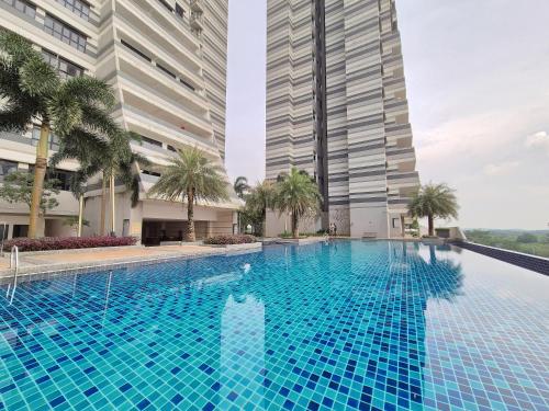 a swimming pool in the middle of a building with tall buildings at Medini Family suites for 3 pax - Next to Legoland in Nusajaya