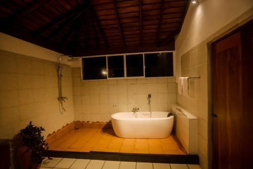 a bathroom with a bath tub in a room at Villa Leela Bentota in Induruwa