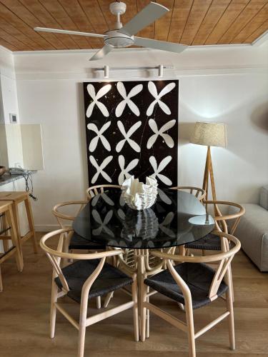 a dining room with a glass table and chairs at Villa 18 in Tangalooma
