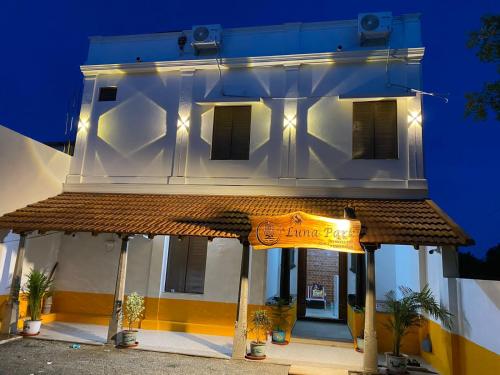 un grand bâtiment blanc avec une enseigne devant dans l'établissement Luna Park & Resort, à Kottakupam
