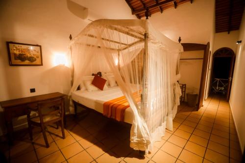 a bedroom with a bed with mosquito net at Villa Leela Bentota in Induruwa