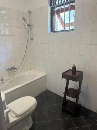 a bathroom with a toilet and a bath tub and a table at Villa Leela Bentota in Induruwa