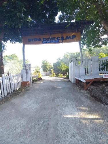 a bus stop with a bench next to a fence at Scuba Republic Beach Bungalows in Bira