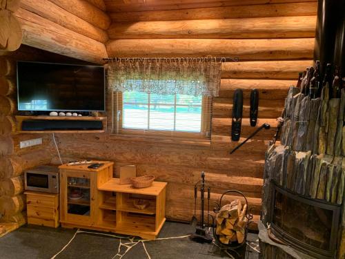 a room in a log cabin with a television and a table at Russet & Rowanberry - Russet House in Paide