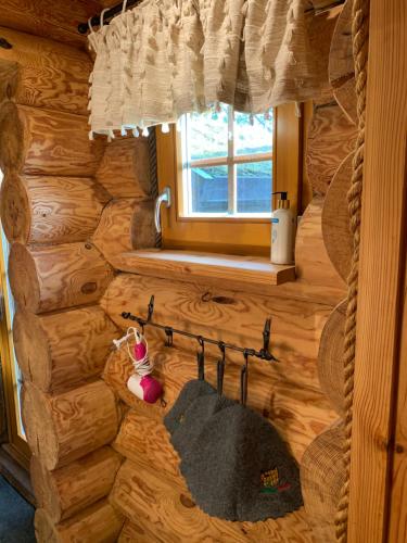 a log cabin bathroom with a towel rack and a window at Russet & Rowanberry - Russet House in Paide