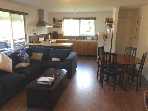 un salon avec un canapé et une table et une cuisine dans l'établissement BLACK DUCK SHACK -Dog friendly -Red Rocks Beach, à Ventnor