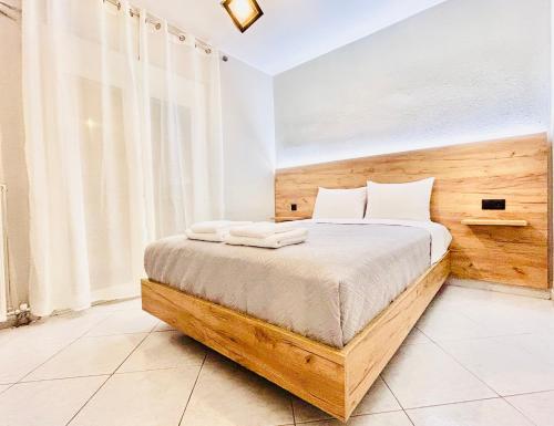 a bedroom with a bed with a wooden headboard at ITHACA Άνετο διαμέρισμα 3ου με θέα in Thessaloniki