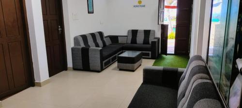 a waiting room with two couches and a table at Marari Praise Beachfront Homestay in Mararikulam