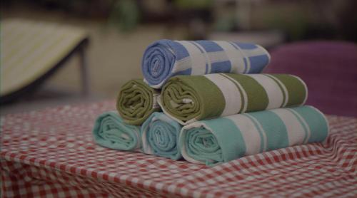 a stack of four towels sitting on top of a table at Marari Praise Beachfront Homestay in Mararikulam