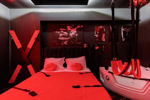 a red bedroom with a bed with red sheets and pillows at Romeo Nights - Private Rooms - Adults Only in Bucharest
