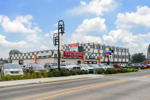 a parking lot with cars parked in front of a building at Days Inn by Wyndham Sylvan Lake in Sylvan Lake