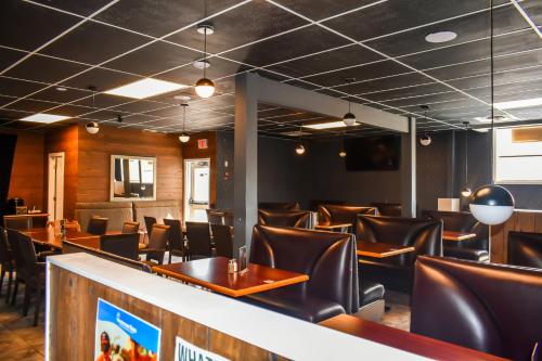 a dining room with leather chairs and tables at Days Inn by Wyndham Sylvan Lake in Sylvan Lake