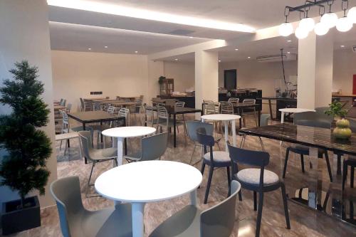 a restaurant with tables and chairs in a room at The 9 Residence Hotel in Bangkok