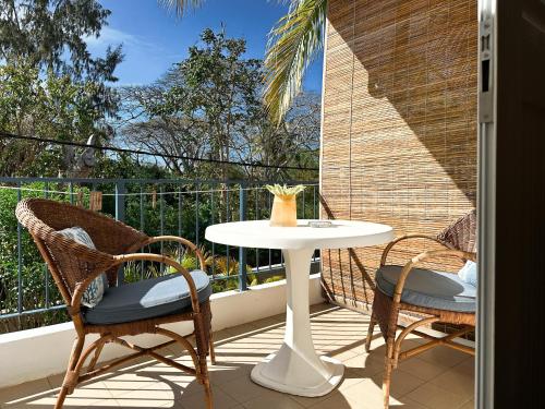 a patio with a table and chairs on a balcony at Blue Bird in Pereybere