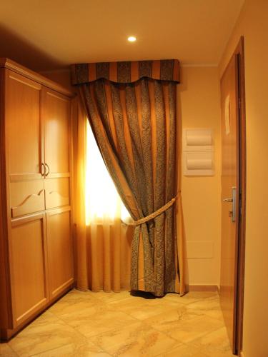 a room with a curtain and a window at Blu Tropical Resort in Zambrone