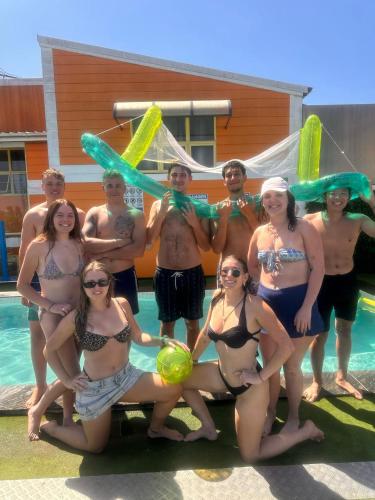 a group of people standing next to a swimming pool at City Backpackers HQ in Brisbane