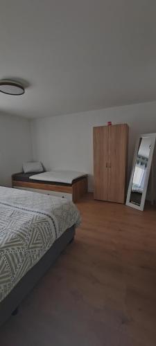 une chambre avec deux lits et une armoire en bois dans l'établissement Appartement spacieux 75m2, à LʼHôpital