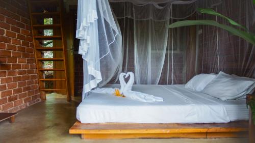 a bedroom with a bed with a white canopy at Eco Breeze - Unawatuna in Unawatuna