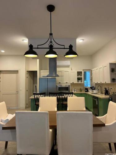 a kitchen with a table and white chairs and a table and chairsktop at Casa de lujo con alberca y playa privada in Cruz de Huanacaxtle