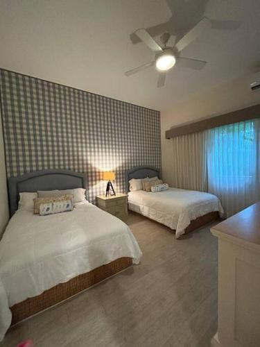 a bedroom with two beds and a ceiling fan at Casa de lujo con alberca y playa privada in Cruz de Huanacaxtle