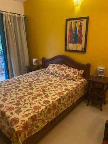 a bedroom with a bed with a flowered bedspread at Riverside Villa at Siolim in Siolim