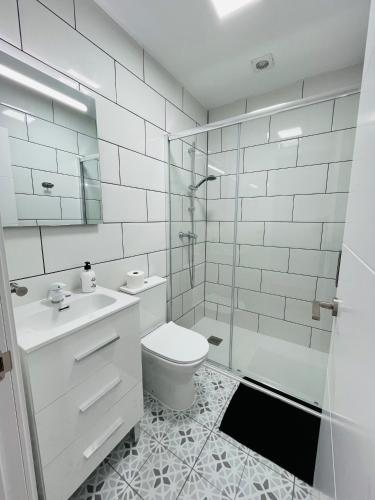 a white bathroom with a toilet and a shower at Renbeck lets 1 in Urcal