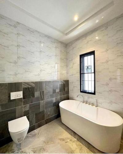 a bathroom with a bath tub and a toilet at HST - 3BED Duplex Chevron - Lekki in Ikuata
