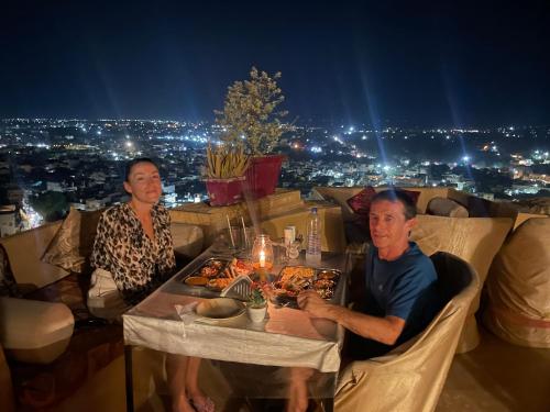 a man and a woman sitting at a table with food at Hotel The Surya Jaisalmer in Jaisalmer