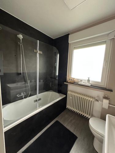 a bathroom with a tub and a toilet and a window at Ferienhaus Pirmasens in Pirmasens