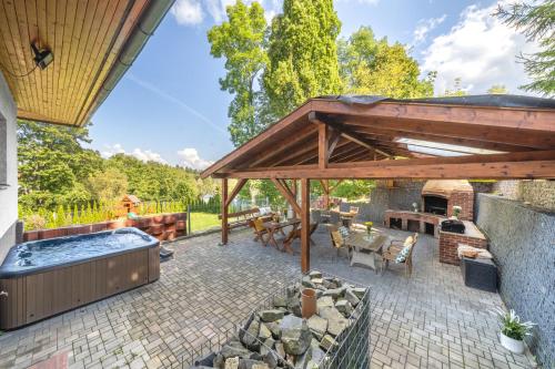 an outdoor patio with a hot tub and a grill at Holiday Home Smržovka in Smržovka