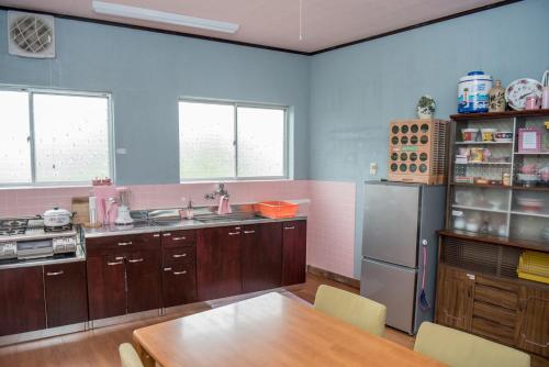 a kitchen with a table and a refrigerator at Benton Guesthouse, Private Nostalgic Showa-era House, former "Akiya" in Imabari