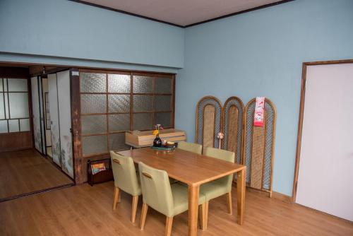 a dining room with a table and chairs and skis at Benton Guesthouse, Private Nostalgic Showa-era House, former "Akiya" in Imabari