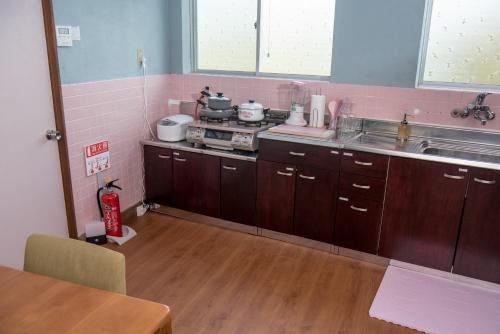 a kitchen with a sink and a stove in it at Benton Guesthouse, Private Nostalgic Showa-era House, former "Akiya" in Imabari