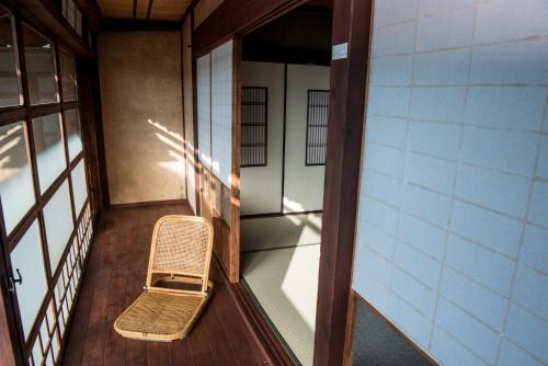 an empty bench sitting on a balcony of a building at Benton Guesthouse, Private Nostalgic Showa-era House, former "Akiya" in Imabari