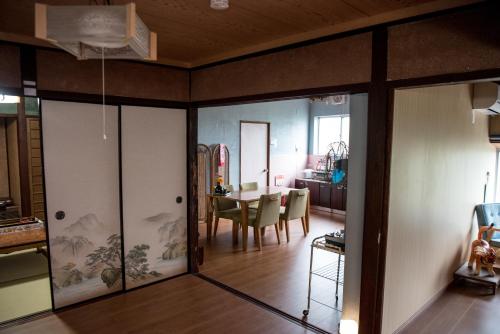 a living room with glass doors and a dining room at Benton Guesthouse, Private Nostalgic Showa-era House, former "Akiya" in Imabari