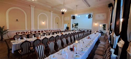 a large banquet hall with tables and chairs with plates on them at Gościniec & SPA Darłowo in Darłowo