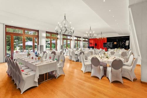 a large banquet hall with white tables and chairs at Le Saint Georges in Gruyères