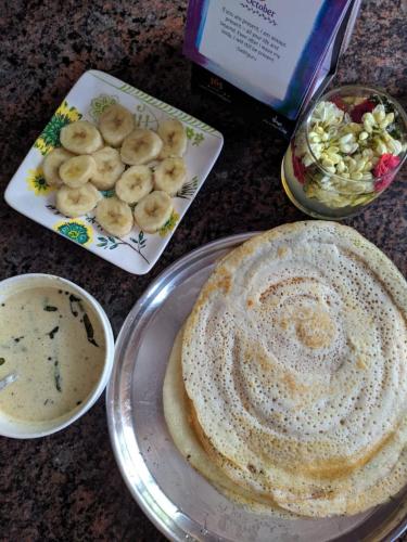 Una mesa con un plato de panqueques y un tazón de sopa. en Blissful Haven, en Auroville