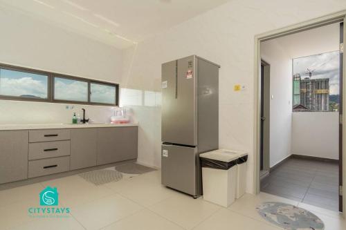 a large kitchen with a refrigerator and a sink at D'Moon Escapes Ampang KL 4BR in Kampong Ulu Kelang