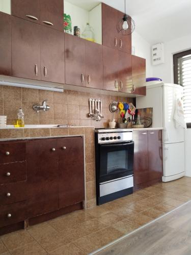 a kitchen with brown cabinets and an oven and a refrigerator at Apartments Colic in Herceg-Novi