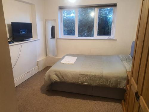 a small bedroom with a bed and a television at Burton Road Serviced Accommodation in Derby
