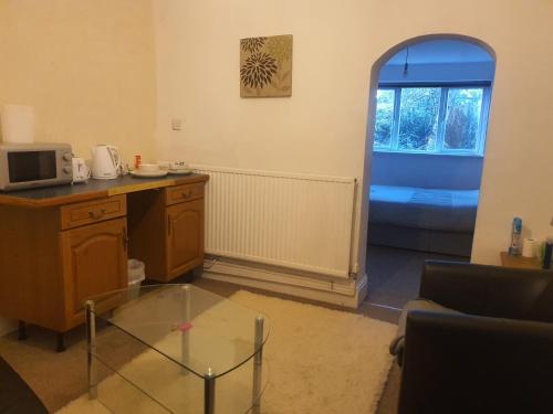 a living room with a glass table and a window at Burton Road Serviced Accommodation in Derby