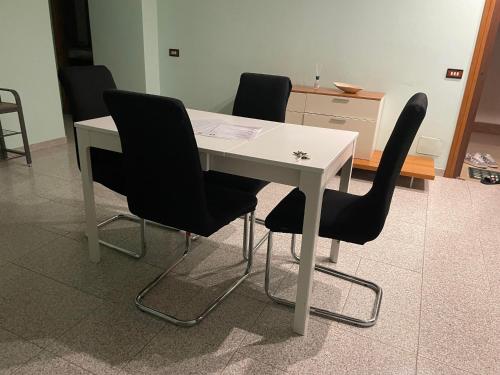 a white table with black chairs in a room at RoMi's house in Colonna