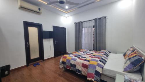 a bedroom with a bed with a quilt on it at Haven Lodge - 7BR Luxury Vacation Home with Mountain View in Islamabad
